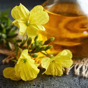 A close up of some yellow flowers and a bottle