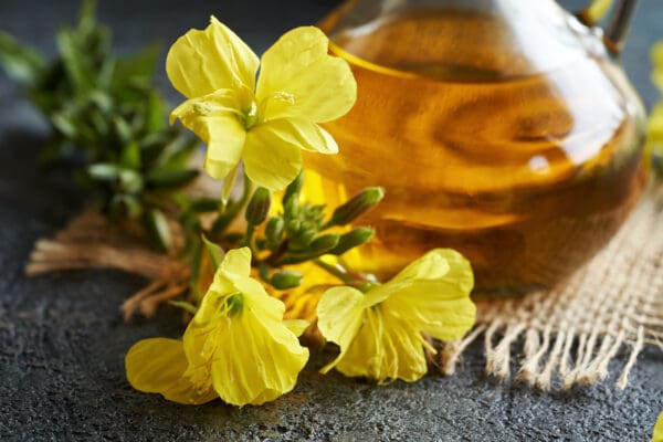 A close up of some yellow flowers and a bottle