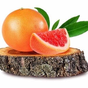 A grapefruit and an orange on a tree stump.