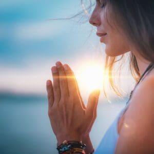 A woman with her hands in prayer.