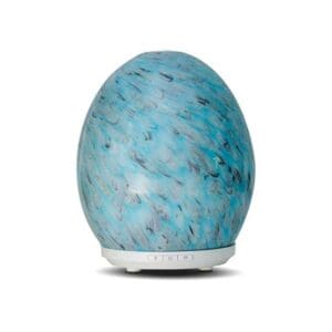 A blue egg shaped diffuser sitting on top of a table.