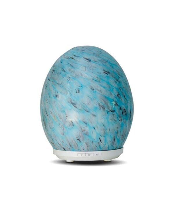 A blue egg shaped diffuser sitting on top of a table.