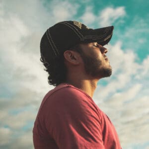 A man with a hat looking up at the sky