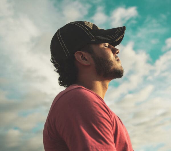 A man with a hat looking up at the sky