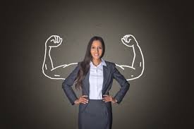 A woman in a suit and tie with her hands on hips.