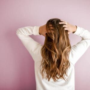 A woman with her hands on her head.