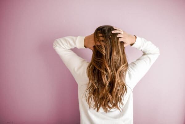 A woman with her hands on her head.