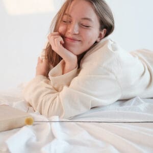 A woman laying in bed with her eyes closed.