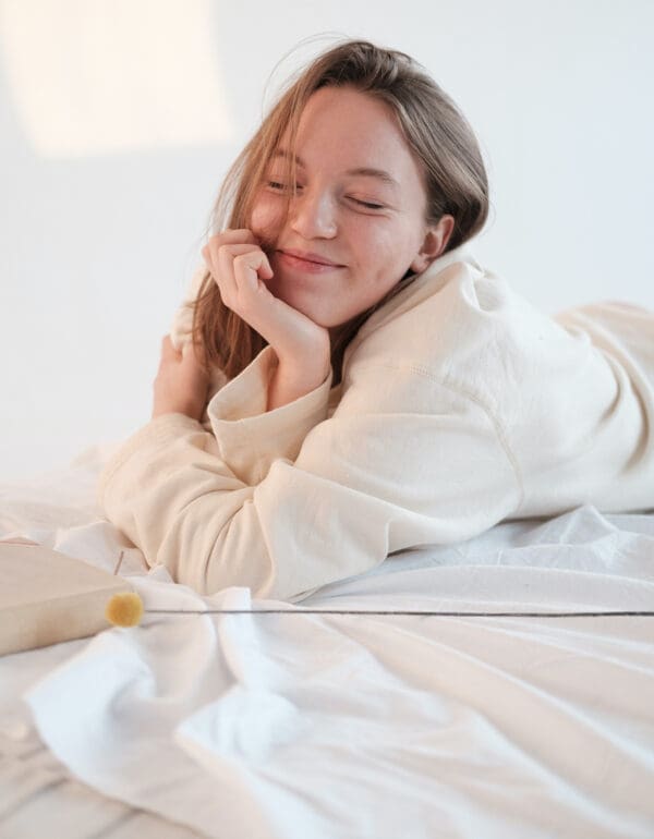 A woman laying in bed with her eyes closed.