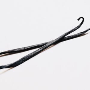 A pair of black hair pins on top of a white surface.