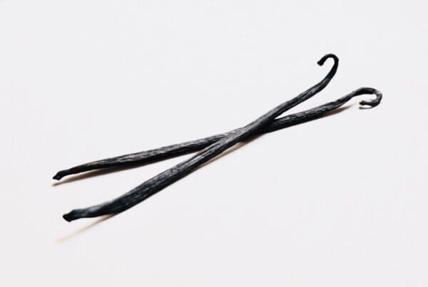 A pair of black hair pins on top of a white surface.