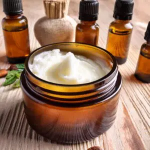 A jar of cream sitting on top of a wooden table.