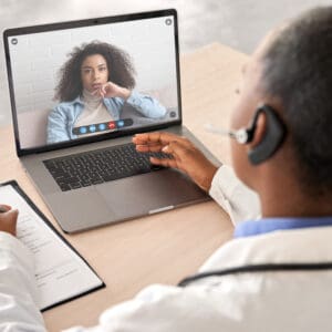 A doctor is on the phone while looking at a patient.