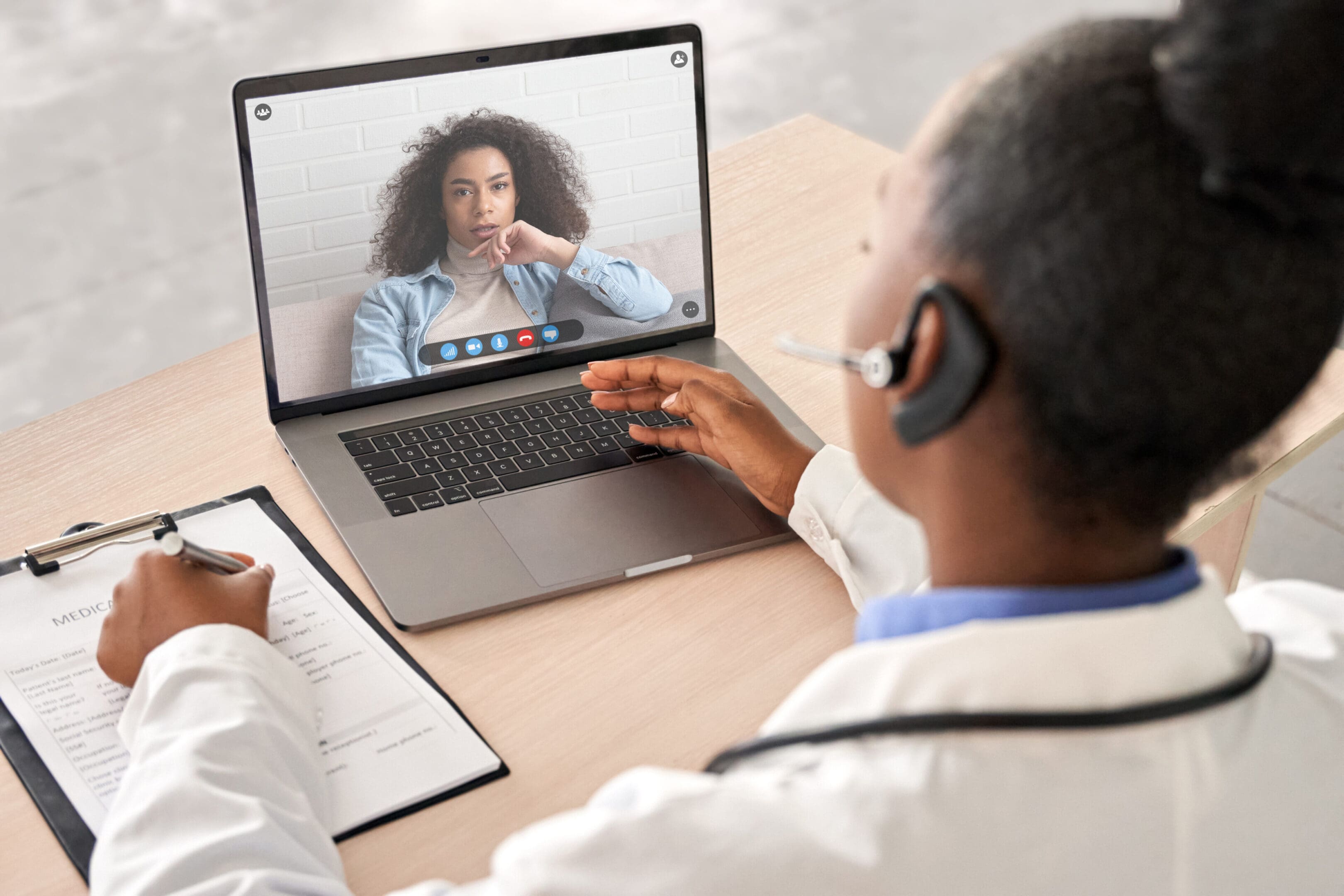 A doctor is on the phone while looking at a patient.