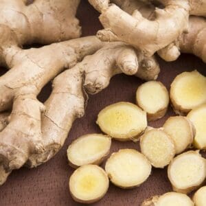 A close up of ginger root and sliced