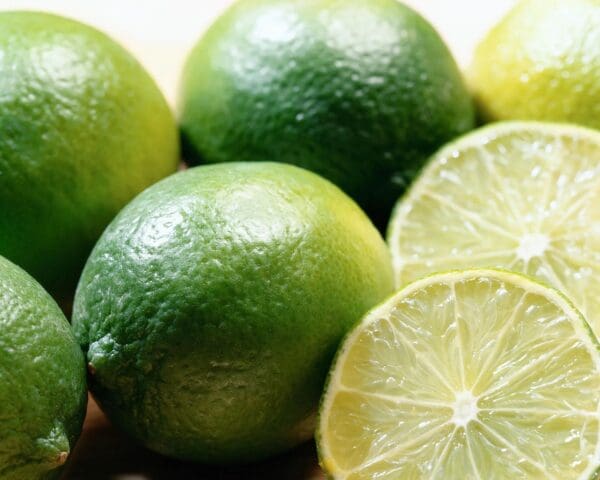 A close up of limes and one cut in half