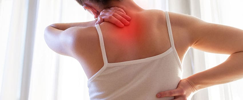 A woman with her hands on the back of her neck.